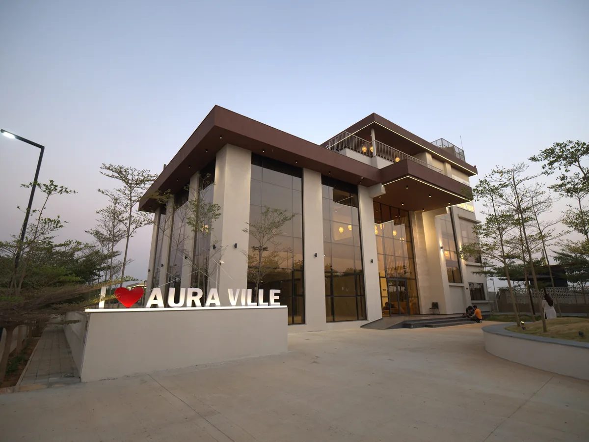 Aura Ville clubhouse entrance at dusk